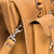 This is the front pocket of a light brown tan leather briefcase for lawyers.