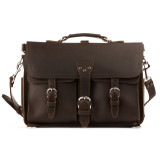 This is a straight on picture of a red brown leather briefcase that is 17 inches wide and has two front pockets on it with a flap over them.