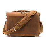 This is the back of a tan brown leather briefcase with the shoulder strap across the back.