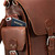 This is the side pocket behind the pocket of a red brown leather backpack.