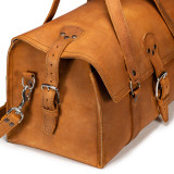 This is a tan brown leather duffle bag that has three straps to close it and has two round handles from the end.