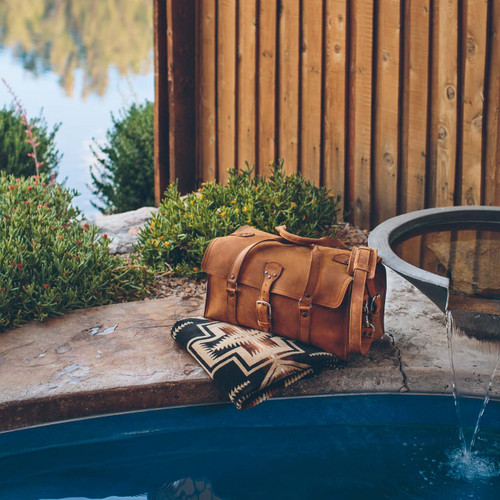 This is a tan brown leather duffle bag at a hot springs in new mexico.