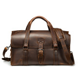 This is a red brown leather duffle bag that has three straps to close it and has two round handles from the front straight on.