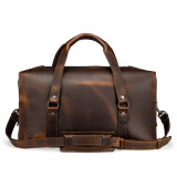 This is a dark brown leather duffle bag that has three straps to close it and has two round handles from the back side.