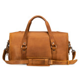 This is a tan brown leather duffle bag that has three straps to close it and has two round handles from the back.