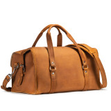 This is a tan brown leather duffle bag that has three straps to close it and has two round handles from the back side.