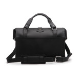 This is the back of a black leather duffle bag with a gladstone bag closure.