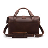 This is the back of a red brown leather duffle bag with a gladstone bag closure.
