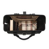 This is the top view of a black leather duffle bag wide open and full overnight clothes.