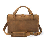 This is the back of a tan brown leather duffle bag with a gladstone bag closure.