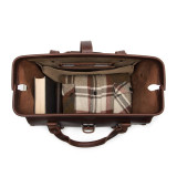 This is the top view of a red brown leather duffle bag wide open and full overnight clothes.