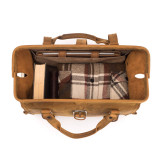 This is the top view of a tan brown leather duffle bag wide open and full overnight clothes.