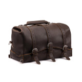 This is a dark brown leather duffle bag with three straps on the front.