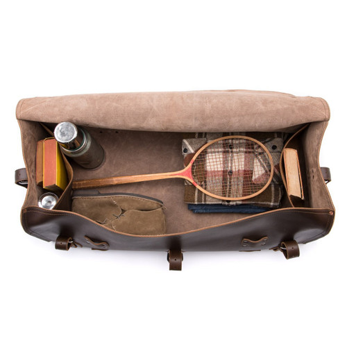 This leather duffle bag is dark brown and has three straps on it . It is showing the inside.