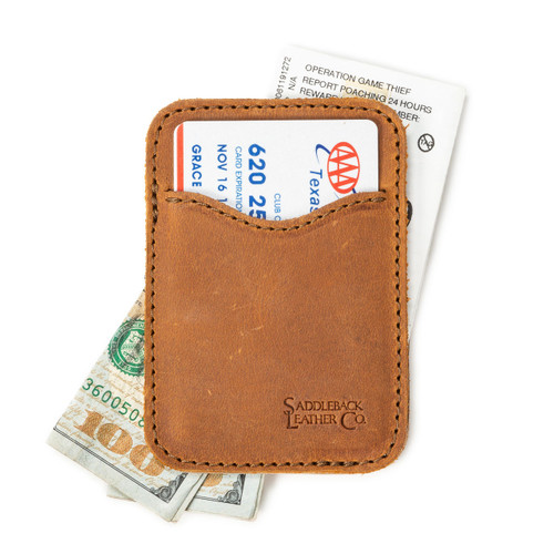 This is a tan brown leather wallet open with cash sticking out both ends.