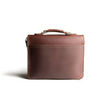 This is the back side of a red brown leather satchel with a front pocket.