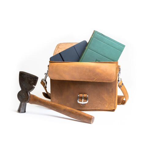 This is the front side of a tan brown leather satchel with a front pocket empty.