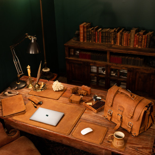 This is a tan brown leather desk pad on a desk with a set of other things.