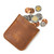 This is a tan brown leather coin purse that has change spilling out of the pouch.