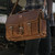 This is a brown leather briefcase with a front view on the hip.