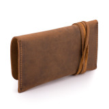 This is a tan brown leather wallet bag with a wrap around it to close it from the back.