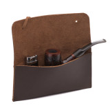 This is a dark brown leather wallet bag wide open with a tobacco pipe.