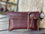 This is a red brown leather wallet bag with passports and yellow cards in it standing up.