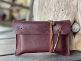 This is a red brown leather wallet bag with passports and yellow cards in it standing up.