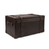 This is a leather trunk that will be a vintage antique one day in a museum. This is the back of the luggage with rivets and leather for a hinge. It is a dark brown steamer trunk that was old time luggage back in the day on trains and ships.