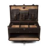 This is a leather trunk that will be a vintage antique one day in a museum. This is the luggage wide open and empty. It is a dark brown steamer trunk that was old time luggage back in the day on trains and ships.