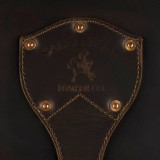 This is a leather trunk that will be a vintage antique one day in a museum. This is the family crest of the brand. It is a dark brown steamer trunk that was old time luggage back in the day on trains and ships.
