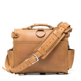 This is the back view with the strap of a tan brown rounded leather satchel.