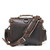 This is the back view with the strap of a dark brown rounded leather satchel.