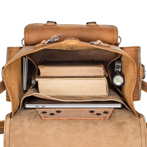 The inside of this tan brown leather backpack is lined with lighter tan pigskin leather