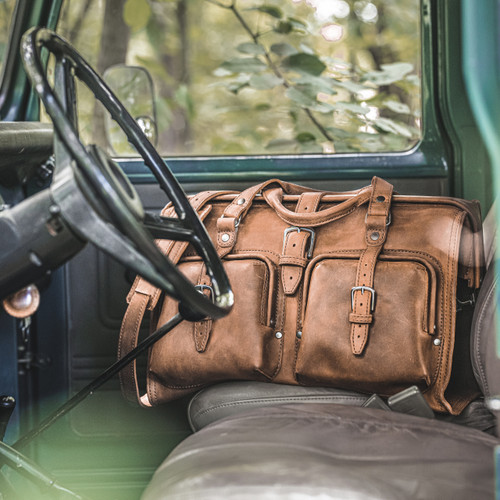 Lifestyle interior truck view of Saddleback Leather's Deep Pocket Leather Duffle Bag in Tan Brown / Tobacco