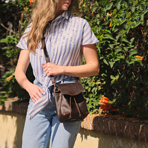 Hobo sack purse in the color dark coffee brown on a woman model outdoors. Made by Saddleback