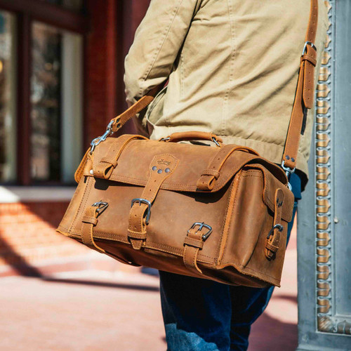 Side Pocket Leather Duffle Bag in Tobaco (light tan leather) being worn crossbody.