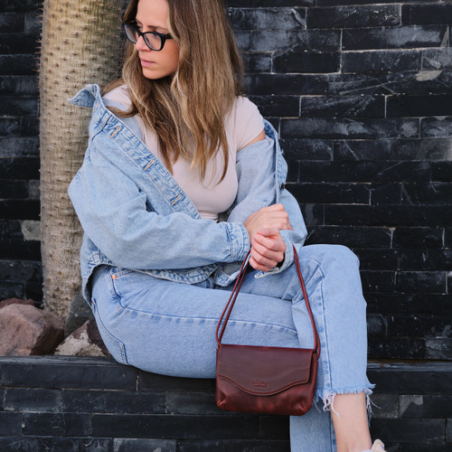 Chestnut color womens clutch on a woman model outdoors. Made by Saddleback
