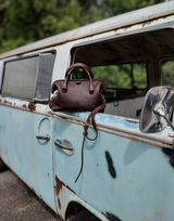 Here is the dark coffee brown leather everyday purse on a vintage car. Made by Saddleback